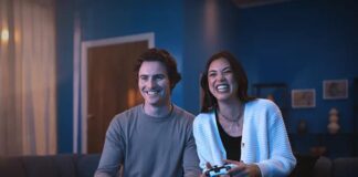 Two people playing PS5 with DualSense wireless controllers.