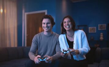 Two people playing PS5 with DualSense wireless controllers.