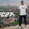 : EA Sports FC 27 promotional image featuring Kylian Mbappé standing above a city football scene.