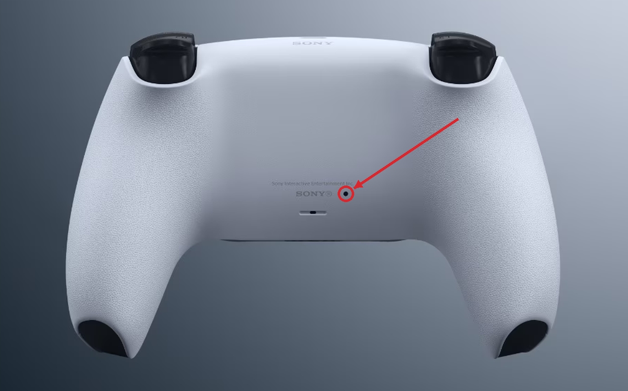 Arrière d’une manette sans fil DualSense avec une flèche rouge pointant vers le bouton de réinitialisation.