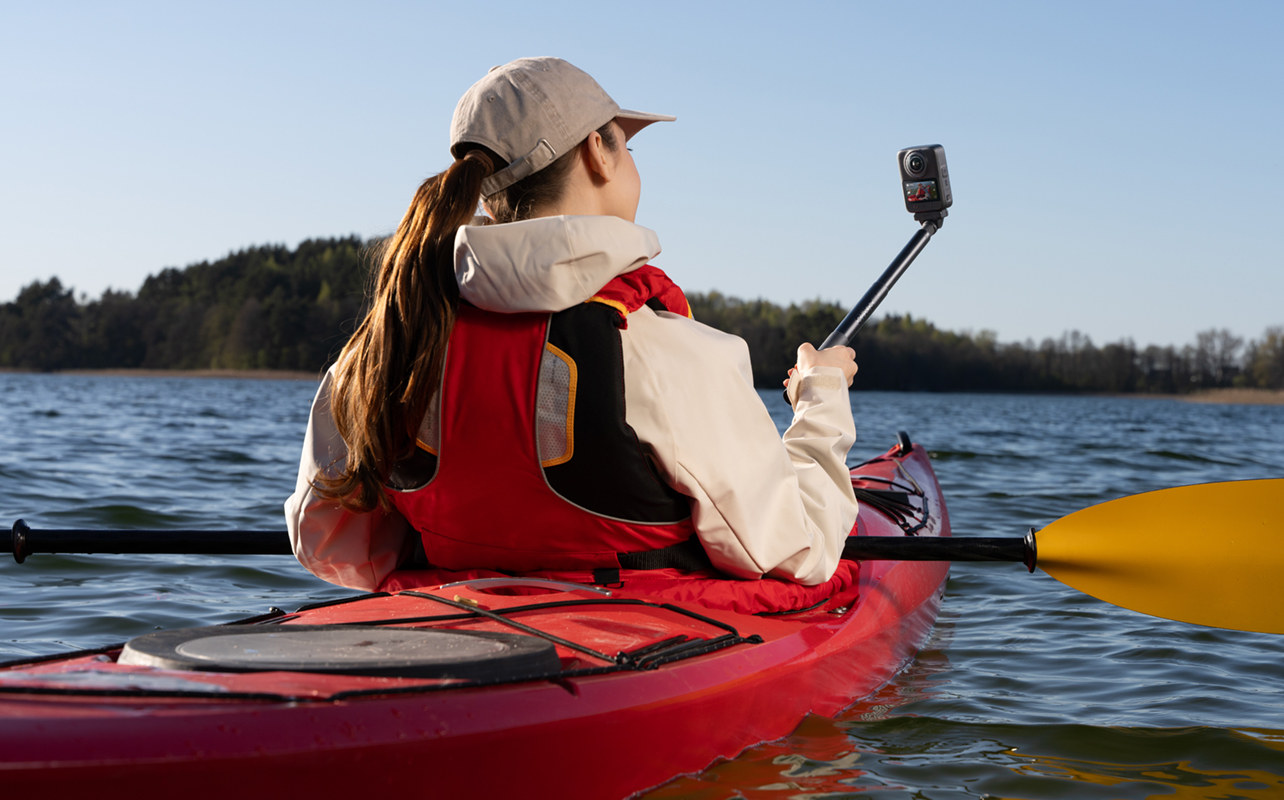 Woman kayaking with DJI Osmo 360 II on a stick.