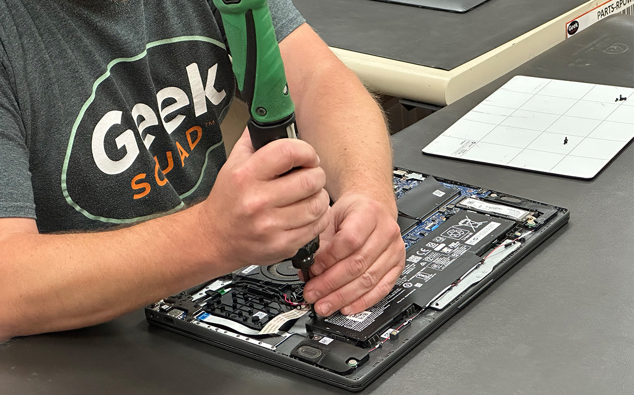 Geek Squad Agent repairing a laptop