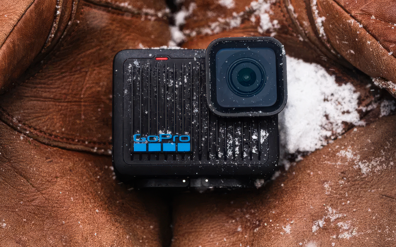 GoPro Hero action camera laid down in fabric and snow.