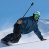 Man snowboarding holding an Insta360 X6.
