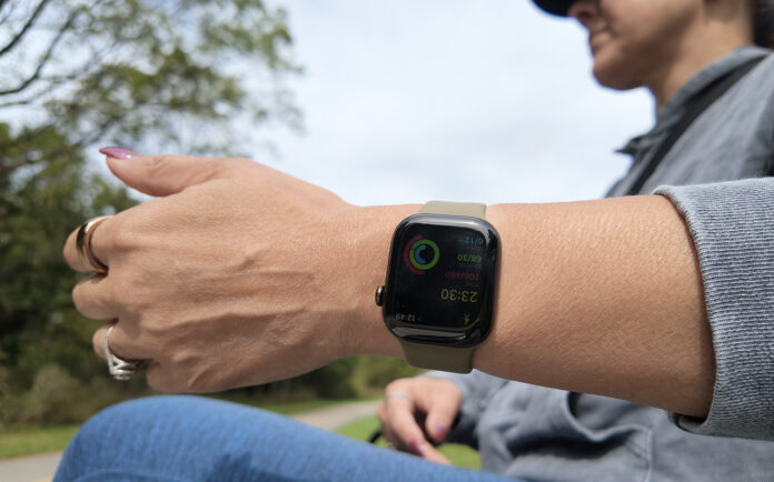 A woman holding her arm out with the Apple Watch Series 12.