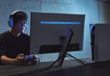 Gamer wearing a Sony INZONE headset while using a controller in front of a gaming monitor.