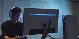 Gamer wearing a Sony INZONE headset while using a controller in front of a gaming monitor.