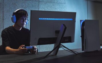 Gamer wearing a Sony INZONE headset while using a controller in front of a gaming monitor.
