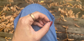 A close-up of the RingConn Gen 3 on a hand resting on a leg outside.