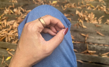 A close-up of the RingConn Gen 3 on a hand resting on a leg outside.