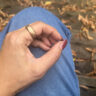 A close-up of the RingConn Gen 3 on a hand resting on a leg outside.